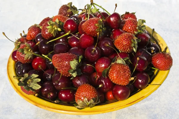 Placa con cerezas rojas y fresa — Foto de Stock