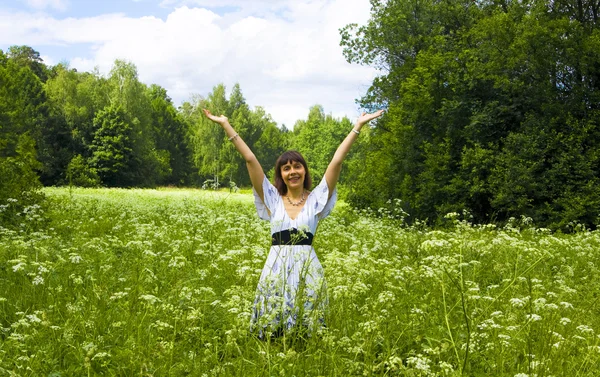Mujer joven en vestido blanco en el prado en flor — Foto de Stock