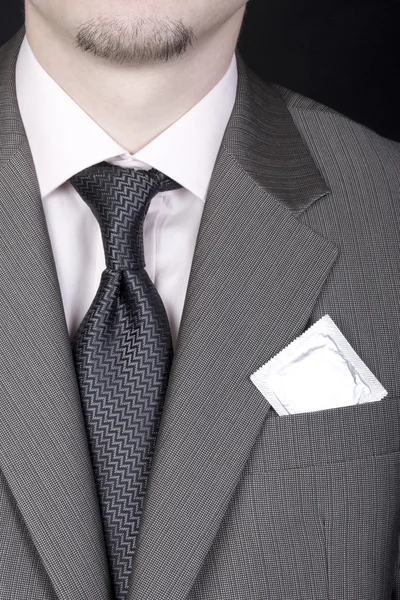 stock image Young man in business suit with condom in pocket