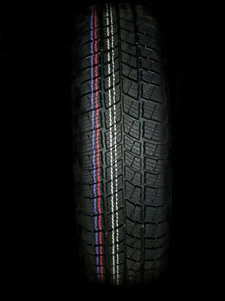 Zimní auto pneumatiky na černém pozadí — Stock fotografie