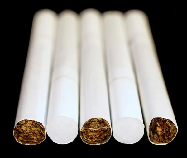 Fumar cigarrillos aislados sobre fondo negro —  Fotos de Stock