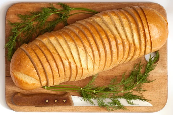 Faca e pão em uma tábua — Fotografia de Stock
