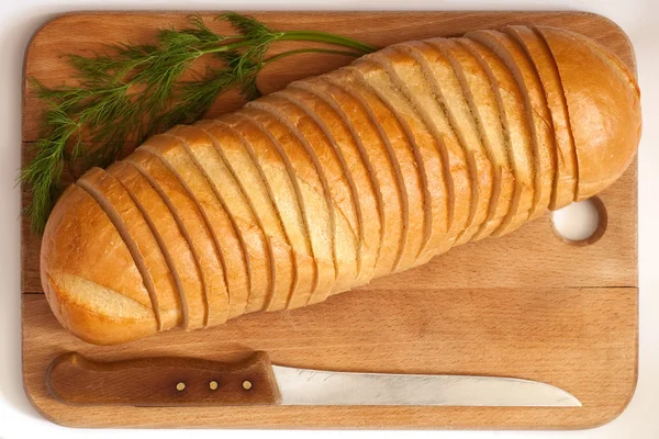 Knife and bread on a board — Stock Photo, Image