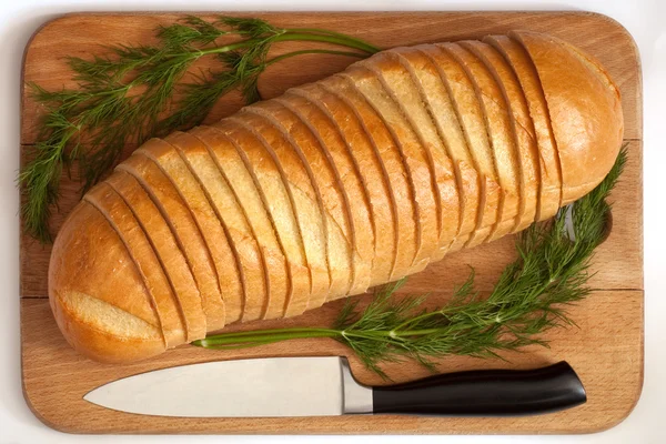 Knife and bread on a board — Stock Photo, Image