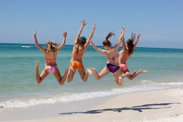 Чотири дівчини-підлітки стрибають на пляжі Ліцензійні Стокові Зображення