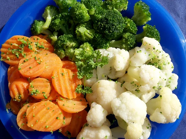 Blandade grönsaker morötter, broccoli, blomkål på en blå platta — Stockfoto