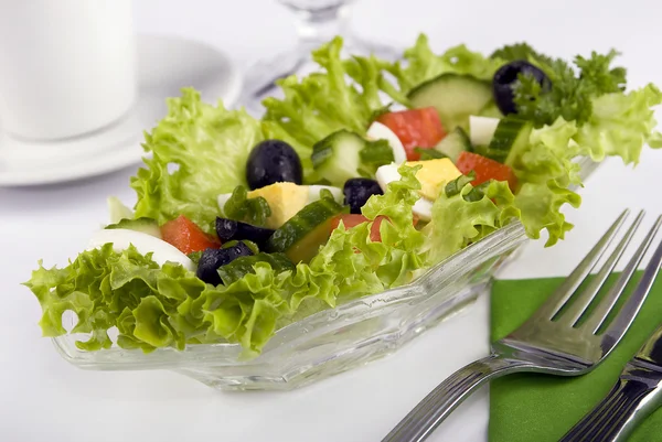 Ensalada con hojas de lechuga fresca, tomate, pepino, huevo, aceitunas, pimienta, sp. Imagen de stock