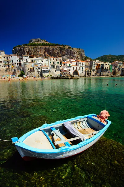 stock image Old boat moored in sea near old town