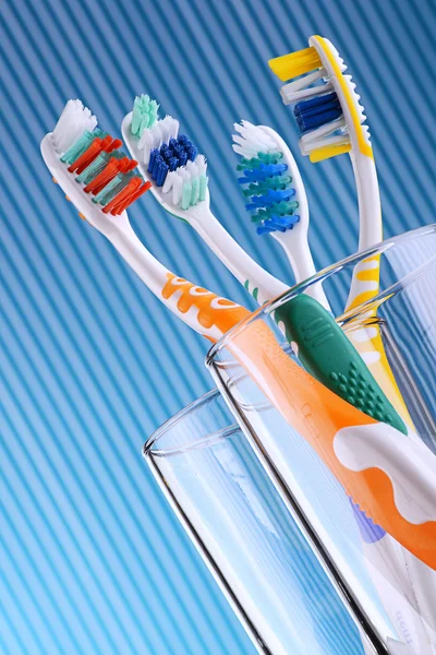 Composición con cuatro cepillos de dientes sobre fondo azul — Foto de Stock