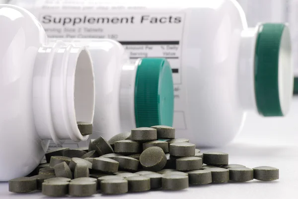 Dietary supplement tablets and containers — Stock Photo, Image