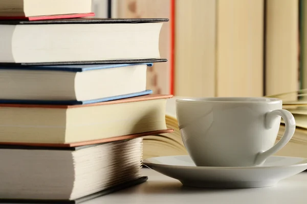 Состав с книгами и чашкой кофе на столе — стоковое фото