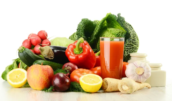 Samenstelling met rauwe groenten en glas sap geïsoleerd op w — Stockfoto