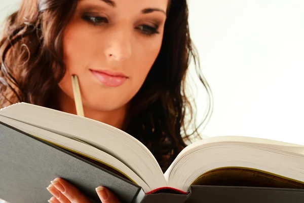 Ung kvinna läser en bok som isolerad på vit — Stockfoto