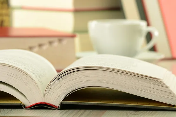 Samenstelling met boeken en kop koffie op tafel — Stockfoto