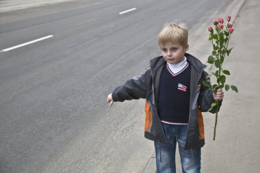 A boy with flowers stops the car