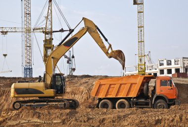 Backhoe loading a dump truck clipart