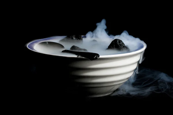 Ciotola fumante di rocce laviche e cucchiaio — Foto Stock