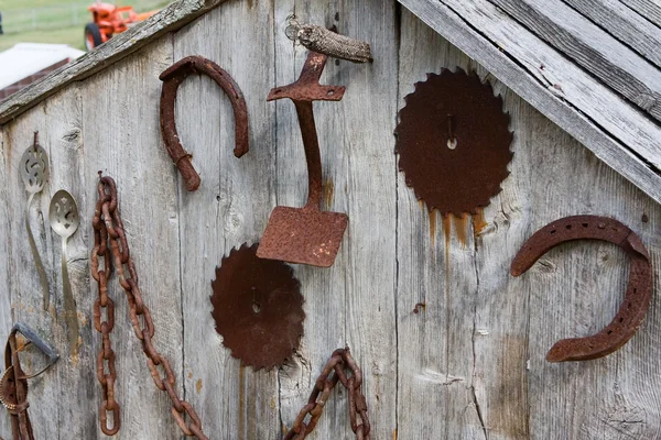 Antik farm eszközök egy fészer fal — Stock Fotó