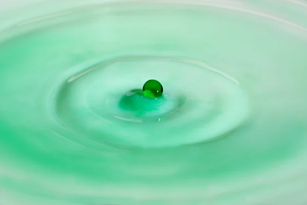 Una goccia verde di acqua spruzzando latte — Foto Stock