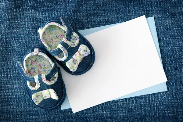 Sapatos de bebê e nota em branco — Fotografia de Stock