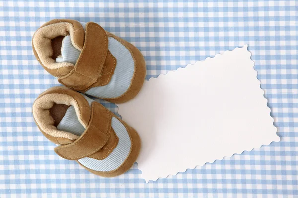Zapatos de bebé y nota en blanco — Foto de Stock