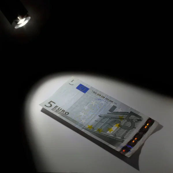 5 euro in het licht van een zaklamp — Stockfoto