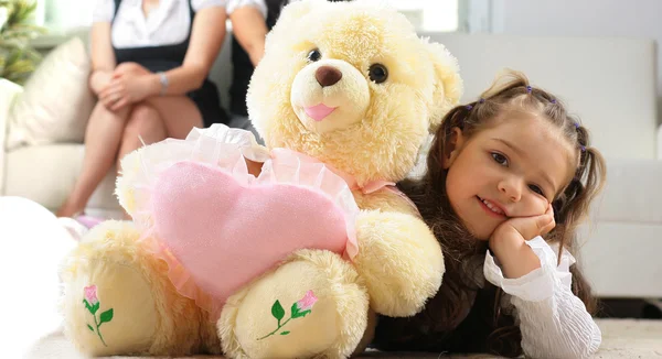 Menina está abraçando grande ursinho de pelúcia — Fotografia de Stock