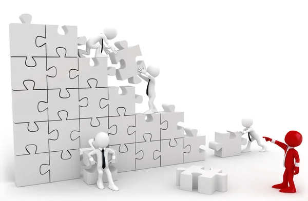 Directeur en medewerkers werken samen om de stukjes van een puzzel — Stockfoto