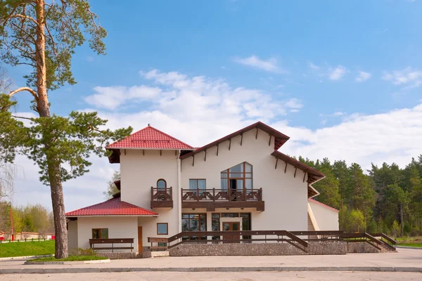 stock image House with red roof against the backdrop of a pine forest