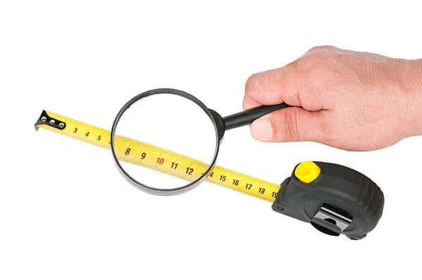 Měřící nástroj ruletou a lupou v ruce — Stock fotografie