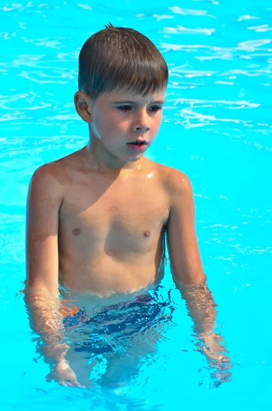 Um menino nada na piscina — Fotografia de Stock