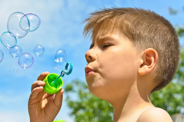 Malý chlapec fouká bubliny — Stock fotografie