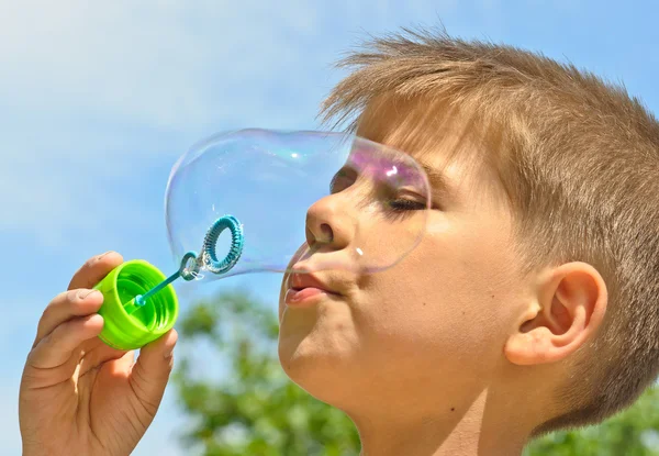 Een jongetje blaast bubbels — Stockfoto
