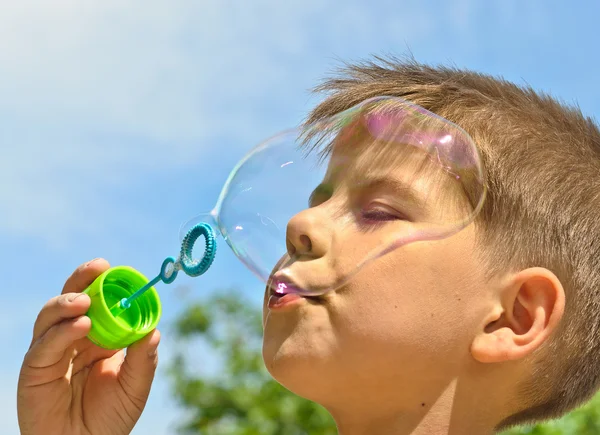 Malý chlapec fouká bubliny — Stock fotografie