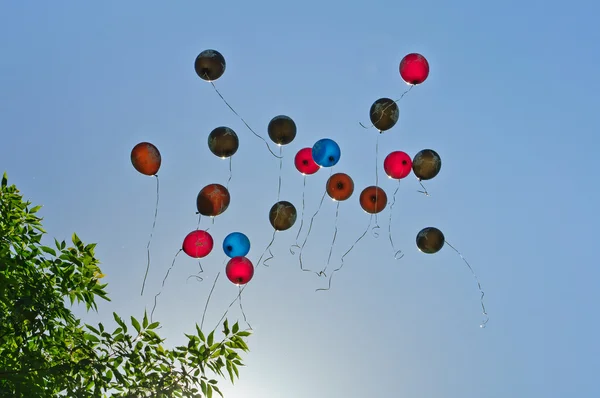 Viele Luftballons fliegen in den blauen Himmel — Stockfoto
