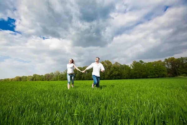 Glückliches Paar läuft auf einem Gras — Stockfoto