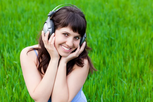 Chica sonriente con los auriculares — Foto de Stock