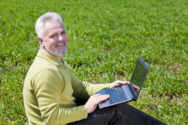 Abuelo feliz con un portátil — Stockfoto