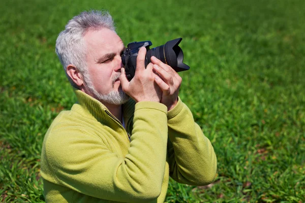 Fotógrafo na grama verde — Fotografia de Stock