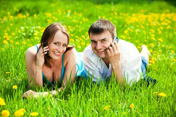 Jeune couple avec téléphones mobiles — Photo