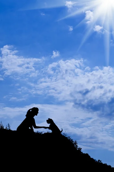 Silhouette of girl train a dog — Stock Photo, Image