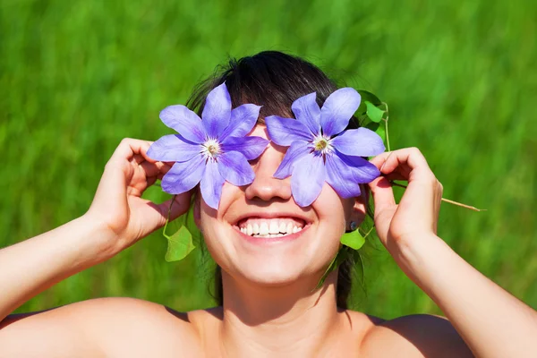 Hübsche Frau versteckt ihre Augen mit Blumen — Stockfoto