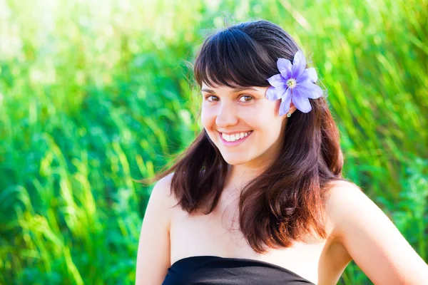 stock image Beautiful woman with purple clematis