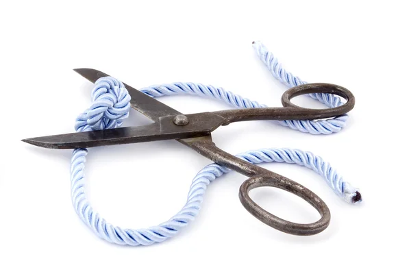 stock image Old big scissors and and knot cuttings on a blue rope