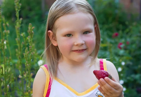 Una bambina con la fragola — Foto Stock