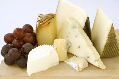 An assortment of cheeses on a cheese-board clipart