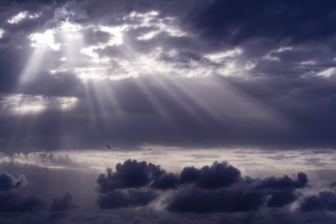 Cloudy stormy sky with sun ray breaking through clipart