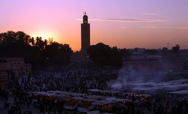 Puesta de sol en la plaza Djemaa El-fna y la mezquita Koutoubia. Marrakech. Marruecos —  Fotos de Stock