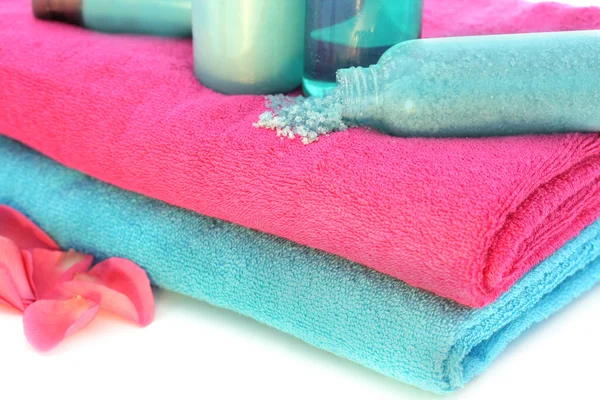 Розовые и голубые полотенца с шампунем, солью, кремом, лосьоном для тела, летучей мышью — стоковое фото