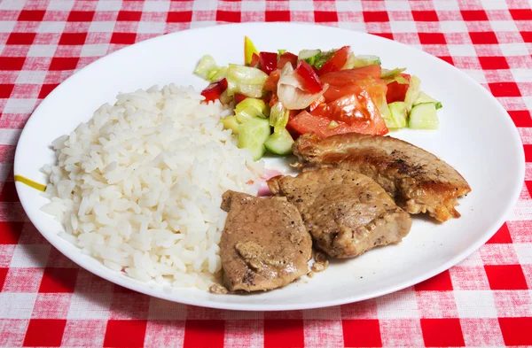 Kött, ris och grönsaker på vit platta. Royaltyfria Stockfoton
